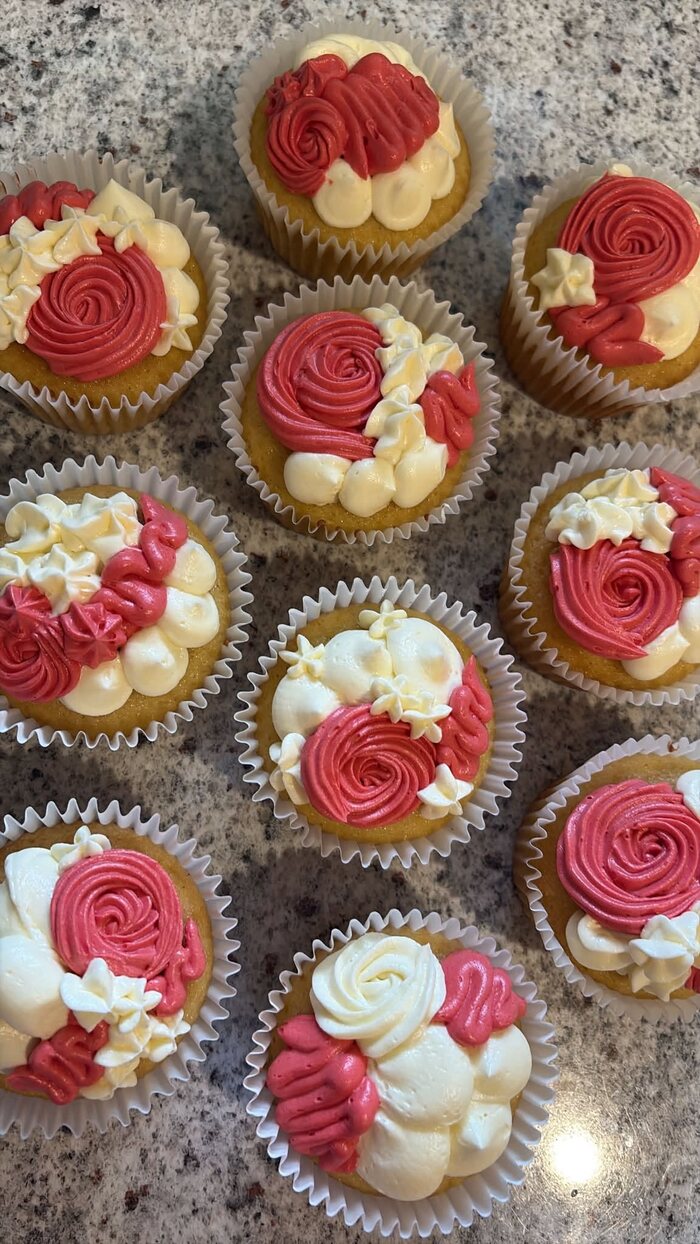 Cupcakes finished with hand-piped red and white buttercream roses