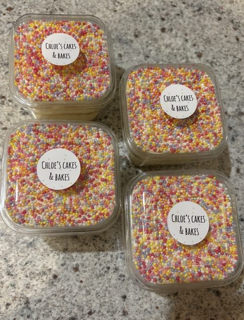 Individual mini layered cakes topped with rainbow sprinkles